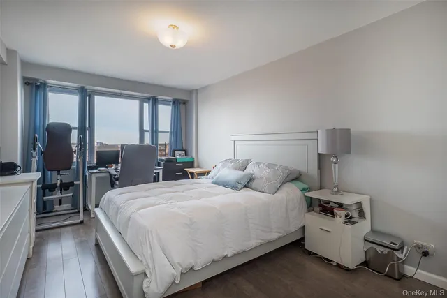 a bedroom with a bed and large windows