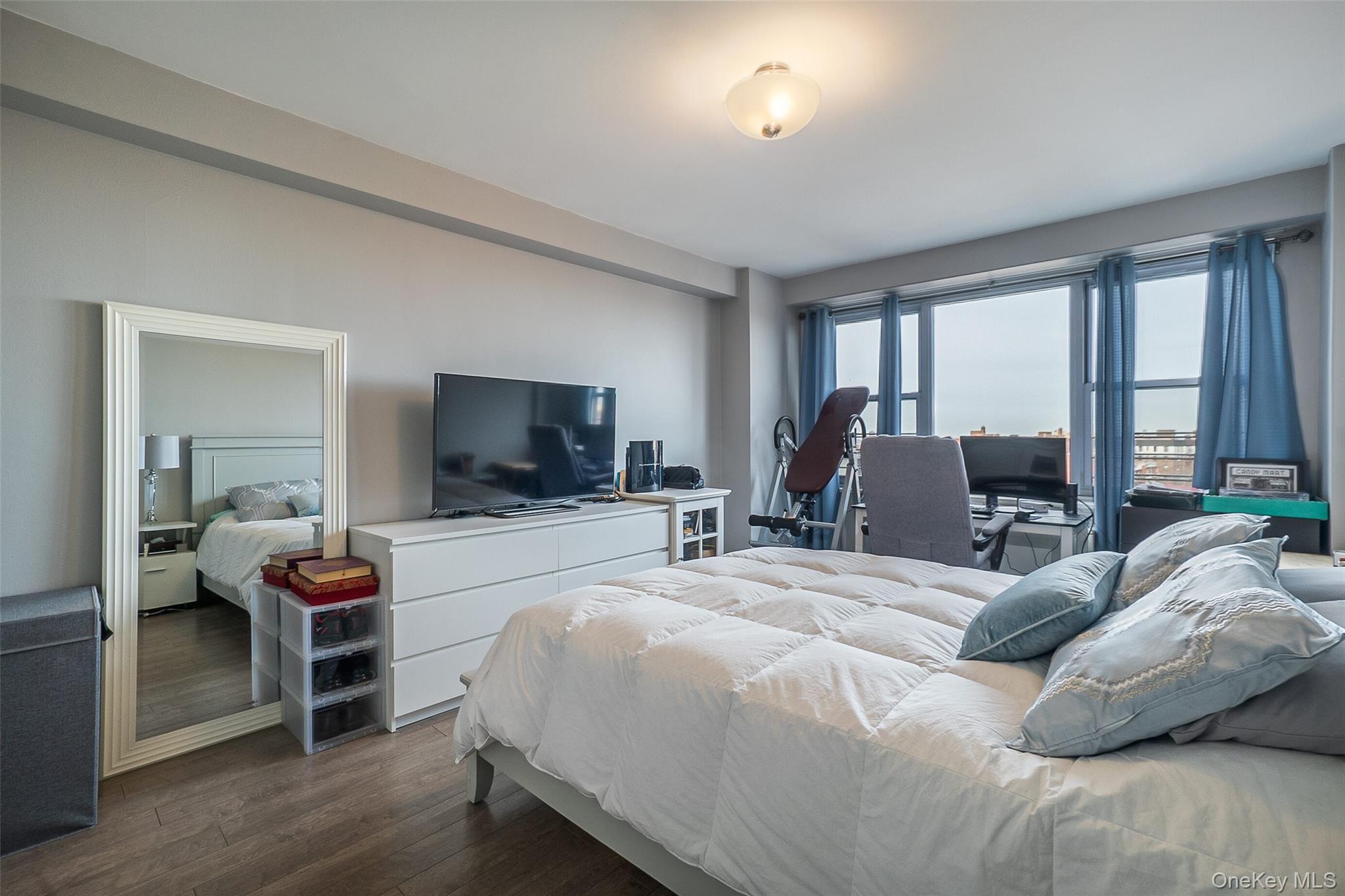 85-15 Main Street, Unit J12 Queens, NY 11435 - Photo 17 of 26 a bedroom with a bed and large windows