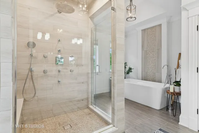 a bathroom with a bathtub and a glass door shower