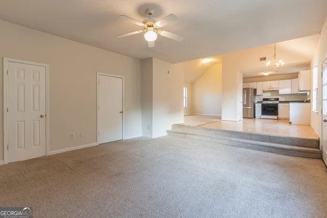 a large white kitchen with kitchen island a sink stainless steel appliances and cabinets