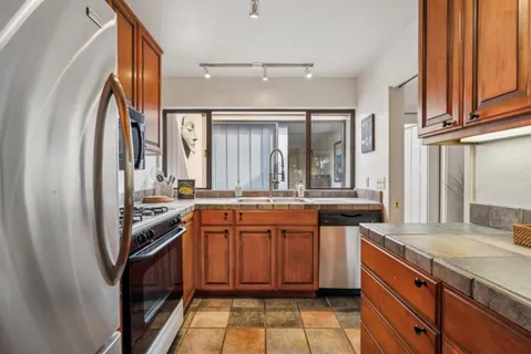 a kitchen with stainless steel appliances granite countertop a sink and a stove