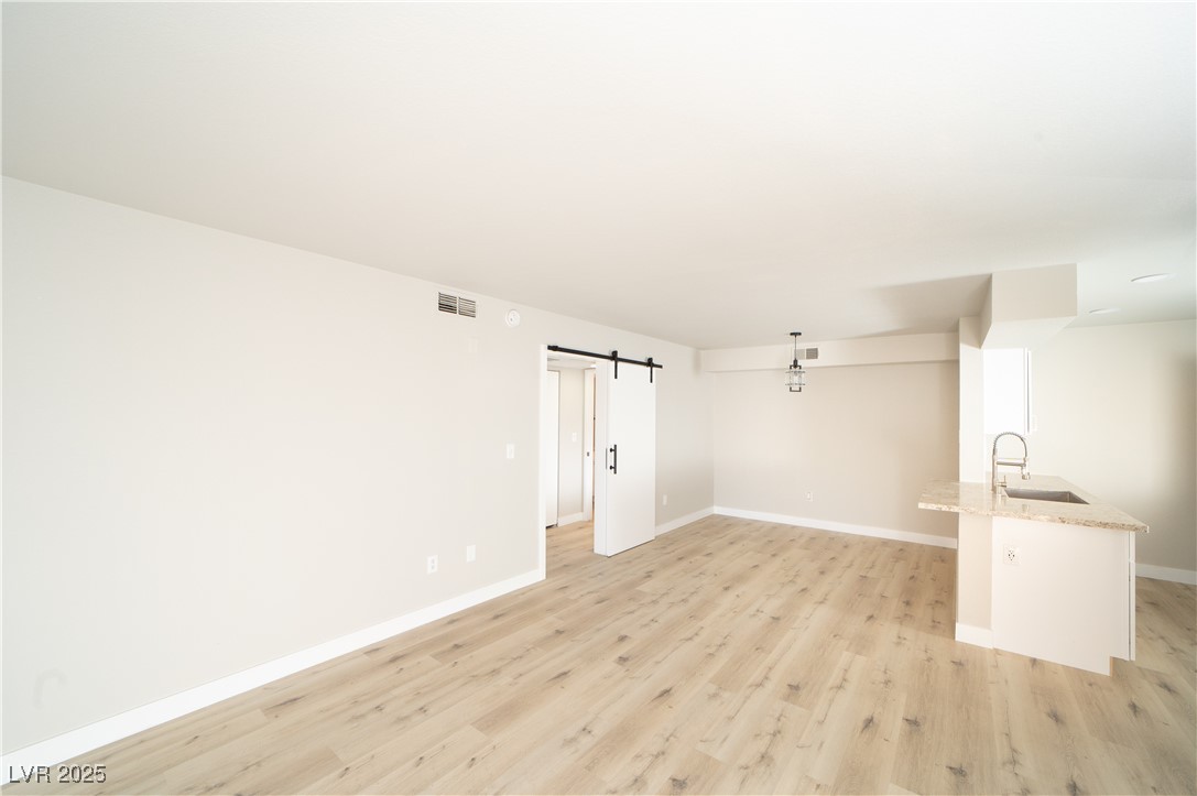 8101 West Flamingo Road, Unit 1057 Las Vegas, NV 89147 - Photo 11 of 38 Spare room with a barn door and light wood-style flooring