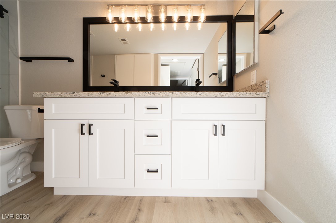 8101 West Flamingo Road, Unit 1057 Las Vegas, NV 89147 - Photo 13 of 38 Bathroom with double vanity and light wood-style flooring