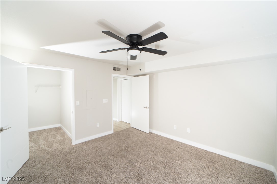 8101 West Flamingo Road, Unit 1057 Las Vegas, NV 89147 - Photo 19 of 38 Unfurnished bedroom with a walk in closet, carpet floors, and a ceiling fan