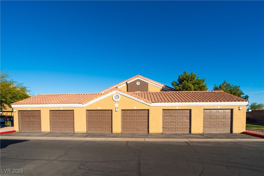 8101 West Flamingo Road, Unit 1057 Las Vegas, NV 89147 - Photo 30 of 38 Mediterranean / spanish-style house featuring stucco siding, a tiled roof, and community garages