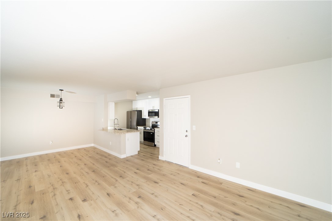 8101 West Flamingo Road, Unit 1057 Las Vegas, NV 89147 - Photo 9 of 38 Unfurnished living room featuring light wood-type flooring and baseboards