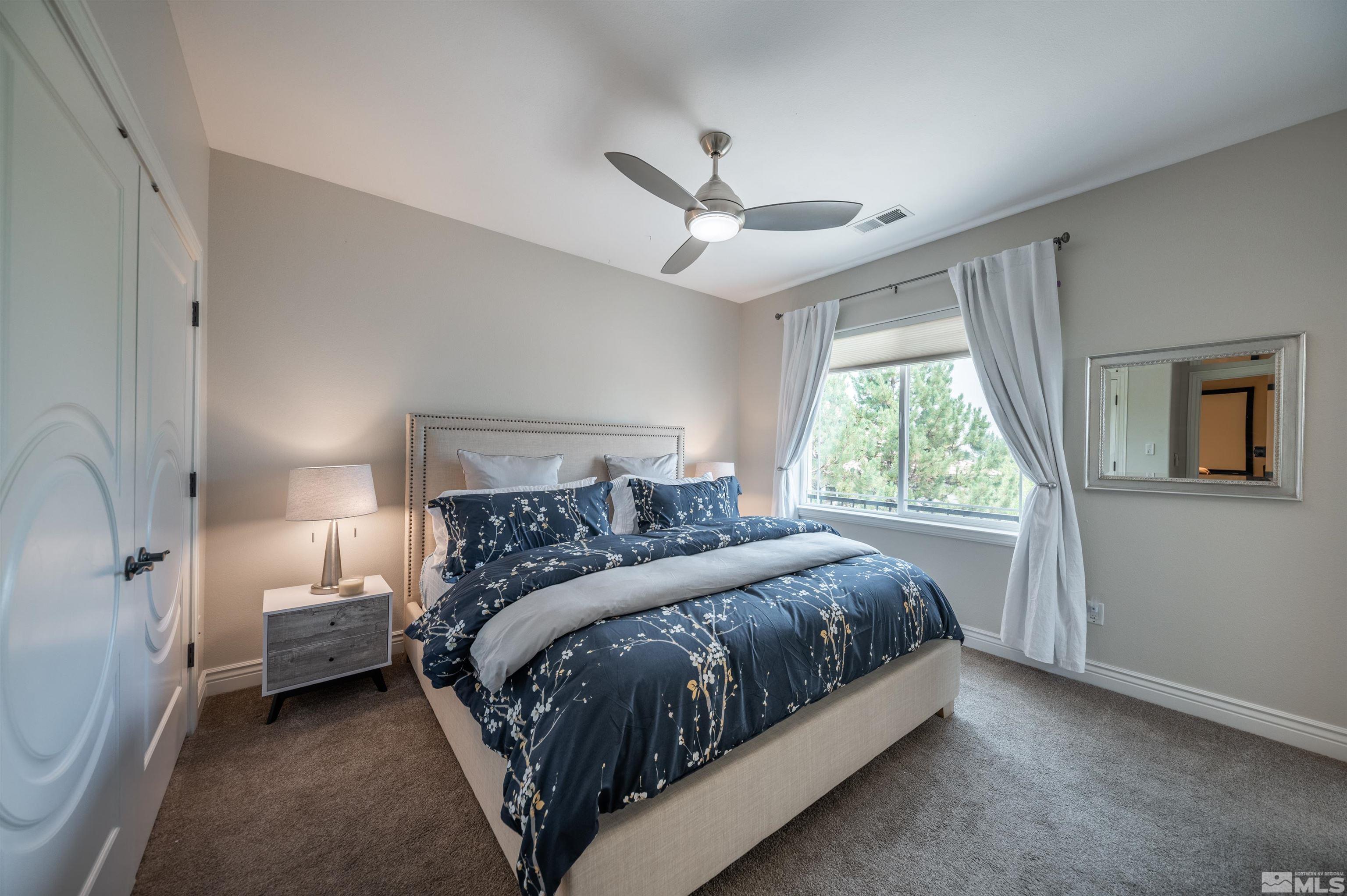 12880 Silver Wolf Road Reno, NV 89511 - Photo 15 of 35 a bedroom with a bed lamp and a large window