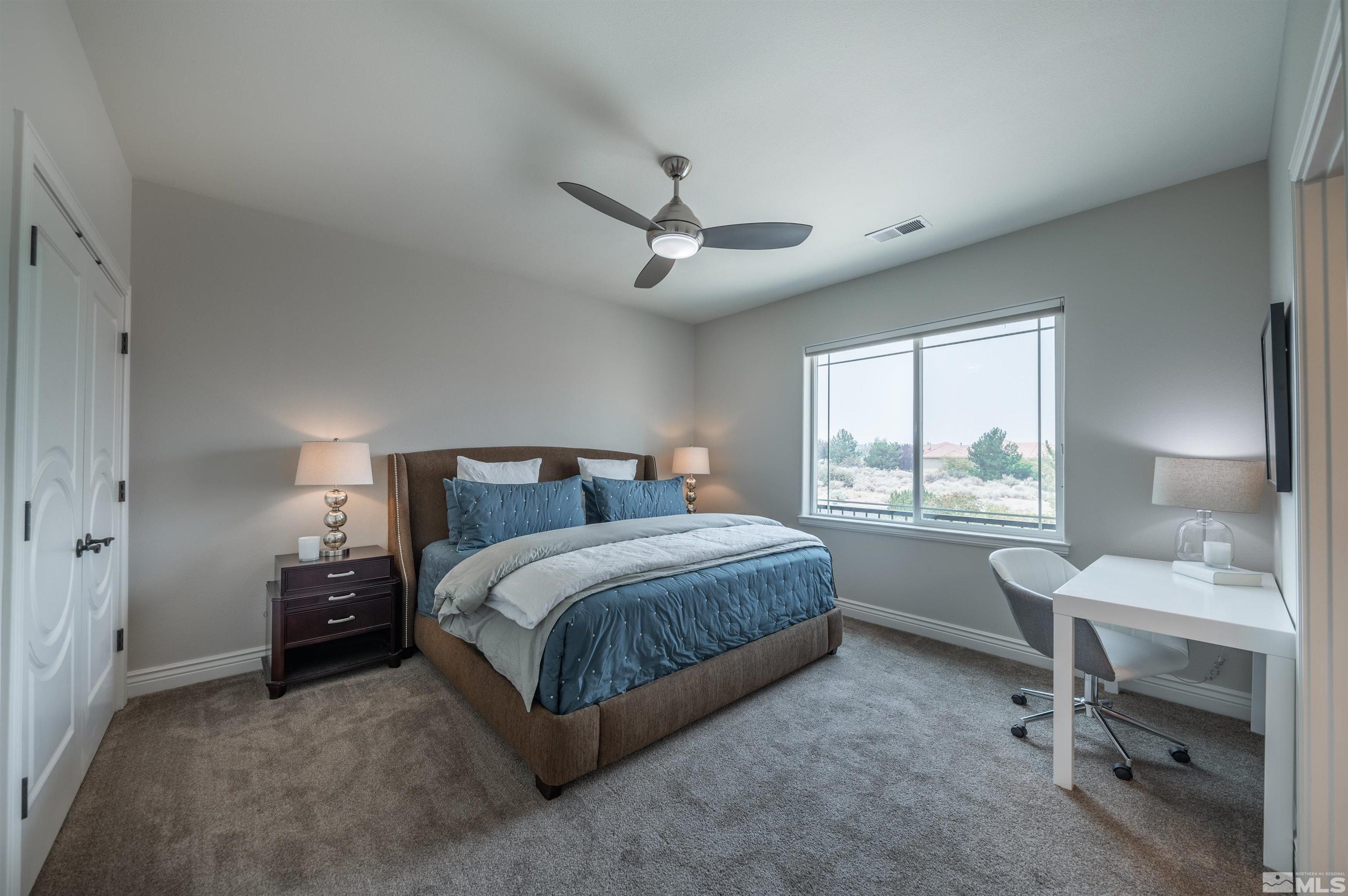 12880 Silver Wolf Road Reno, NV 89511 - Photo 17 of 35 a spacious bedroom with a bed a table and a window