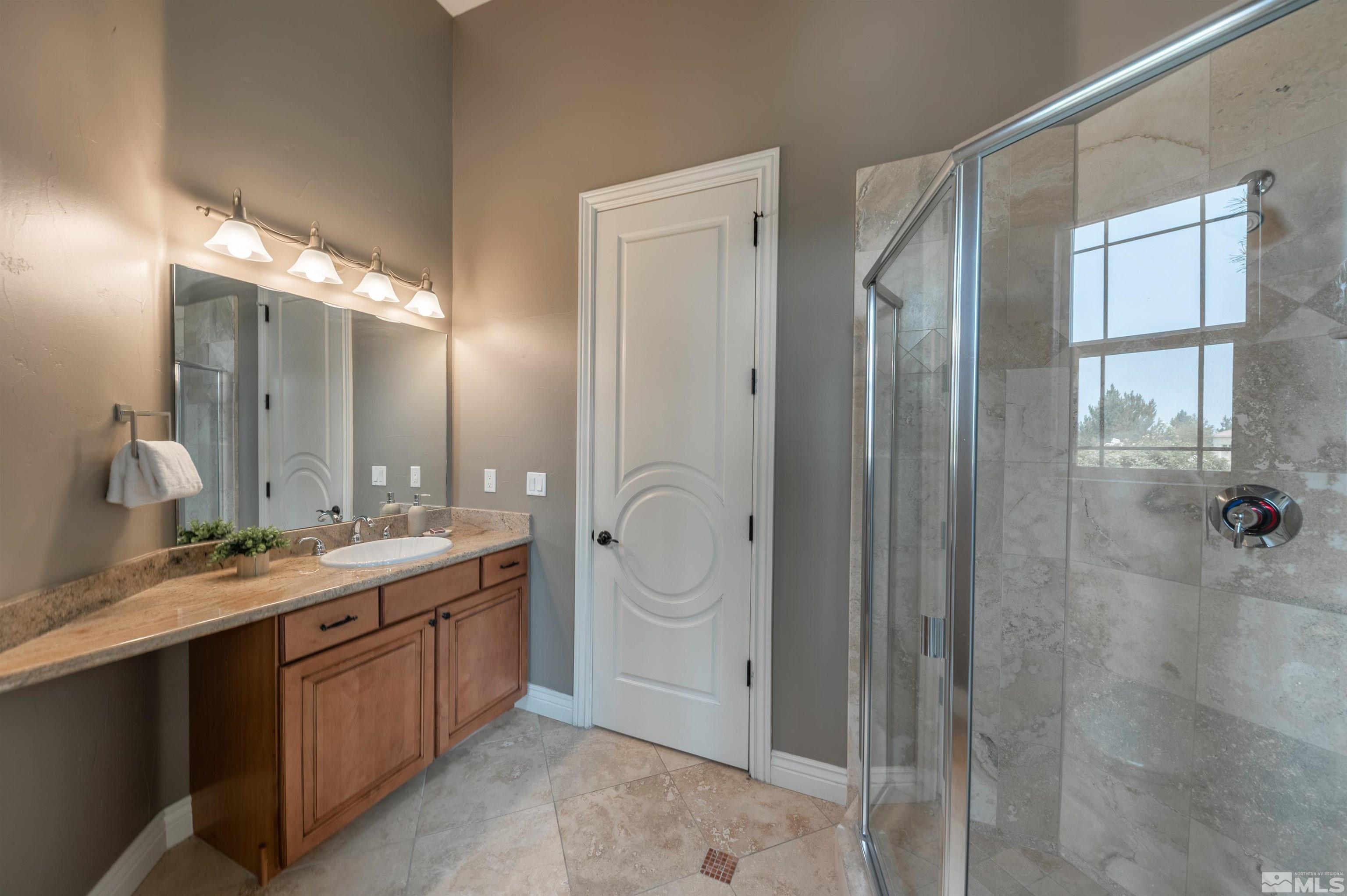12880 Silver Wolf Road Reno, NV 89511 - Photo 21 of 35 a spacious bathroom with a double vanity sink mirror double and shower