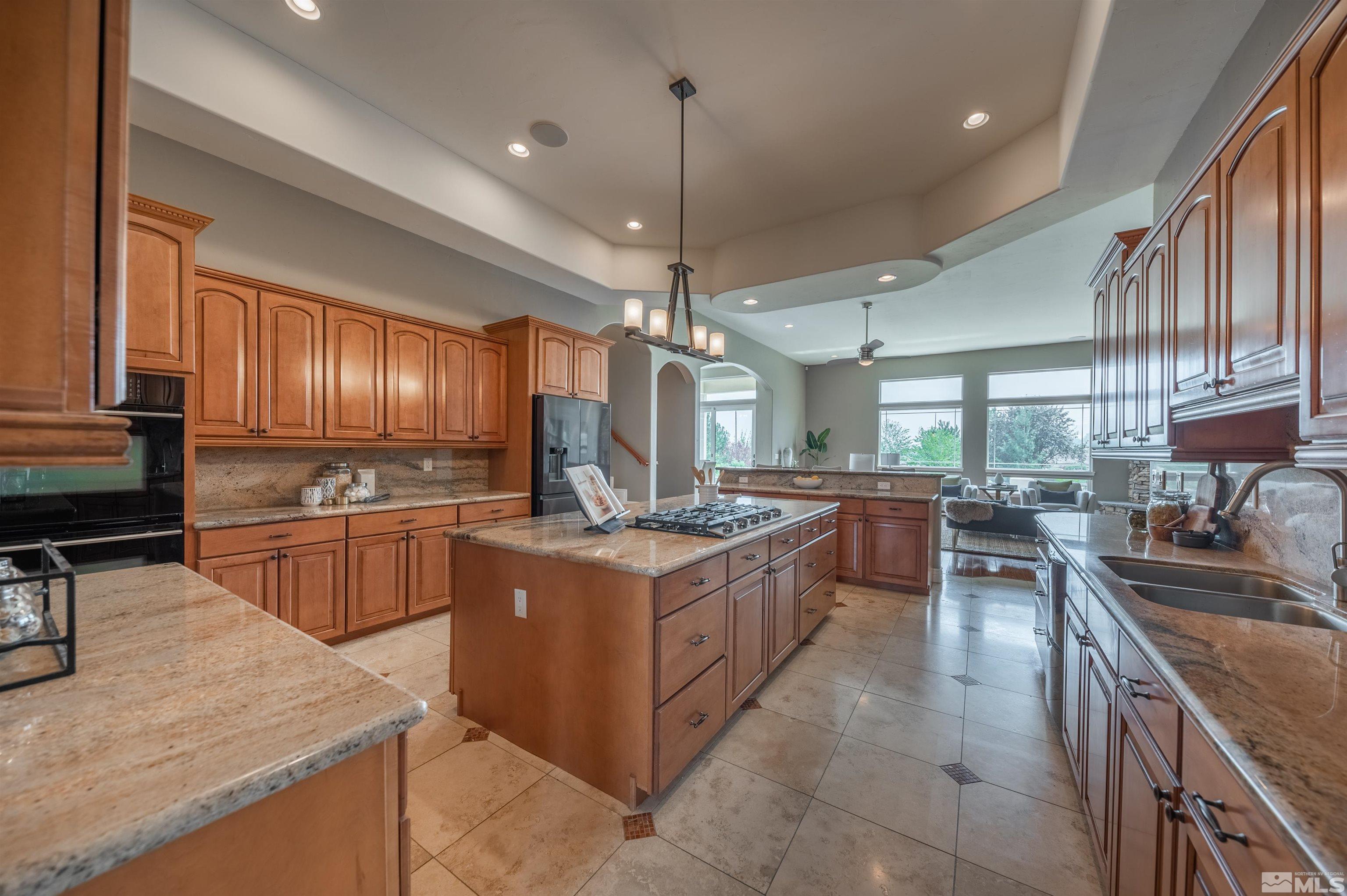 12880 Silver Wolf Road Reno, NV 89511 - Photo 8 of 35 a kitchen with stainless steel appliances granite countertop a stove oven and sink
