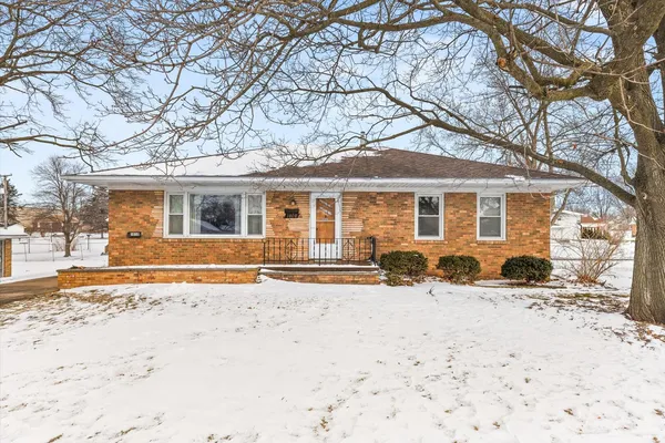 a front view of a house with a yard covered in snow