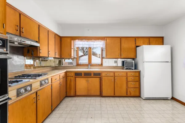 a stove top oven sitting inside of a kitchen