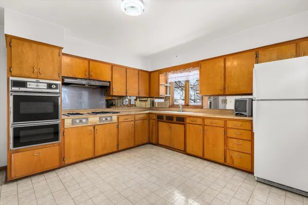 a kitchen with stainless steel appliances granite countertop a refrigerator and a sink