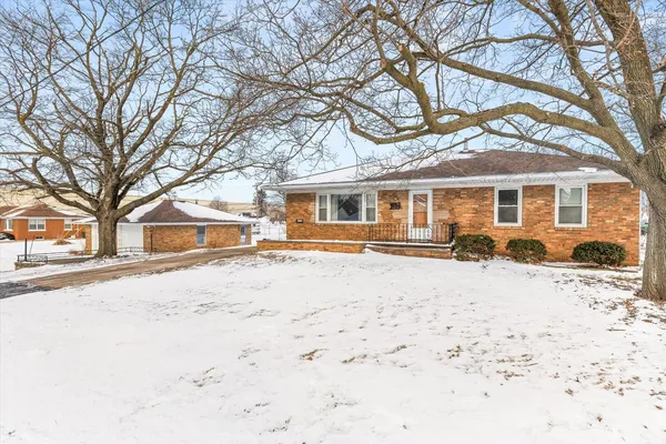 a front view of a house with a yard covered in snow