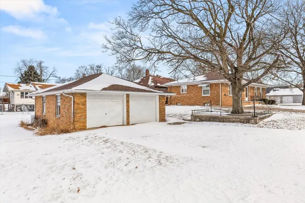 a front view of a house with a yard covered in snow
