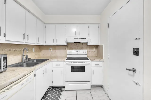 a kitchen with cabinets appliances and a sink