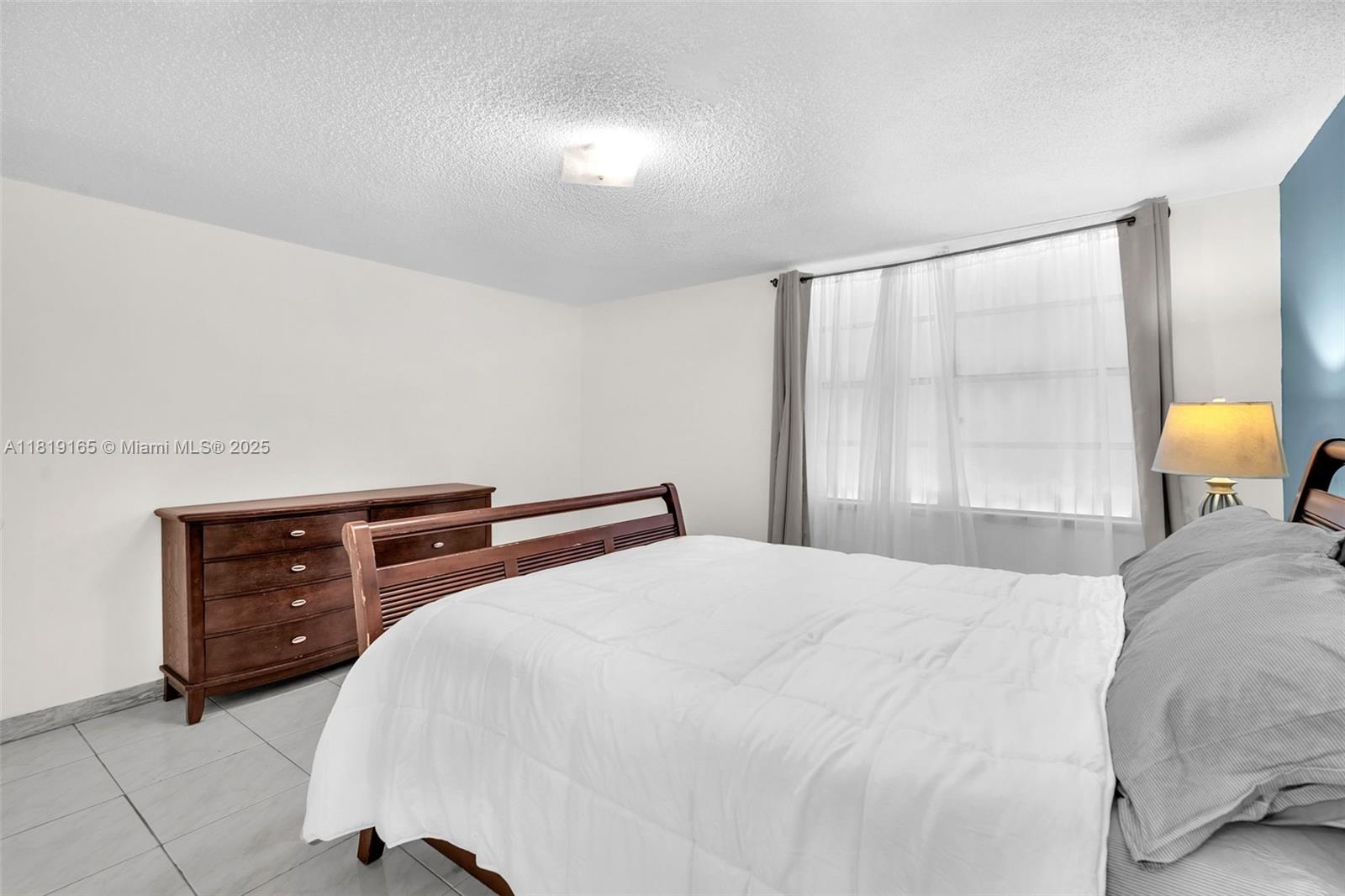 17800 Atlantic Boulevard, Unit 303 Sunny Isles Beach, FL 33160 - Photo 15 of 26 a bedroom with a bed and window