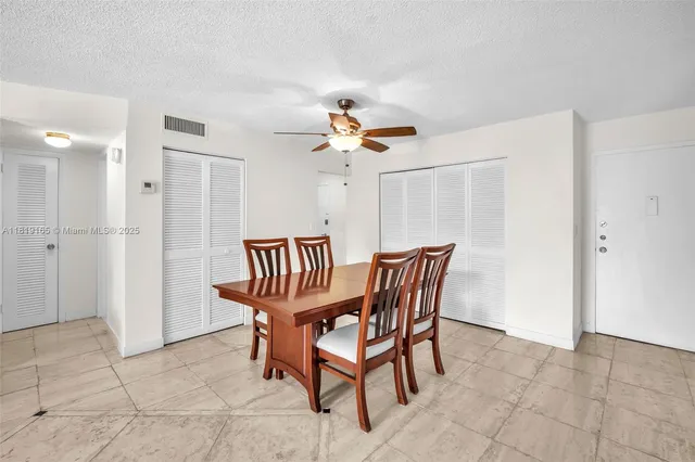 a view of a livingroom with a dinning area hardwood floor and a ceiling fan
