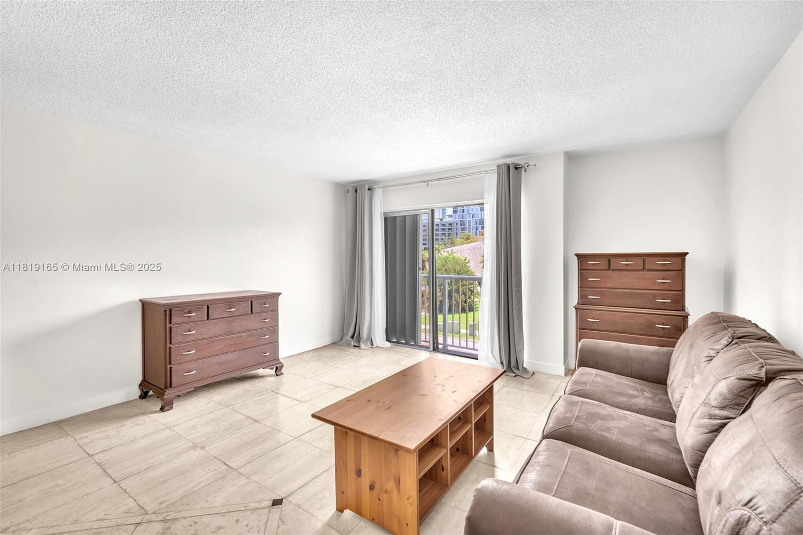 17800 Atlantic Boulevard, Unit 303 Sunny Isles Beach, FL 33160 - Photo 8 of 26 a living room with furniture and a window