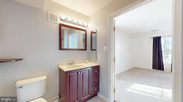 a bathroom with a toilet sink and mirror