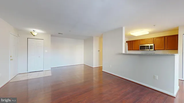 a view of a kitchen with wooden floor and a window