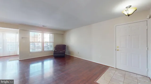 an empty room with piano table and windows