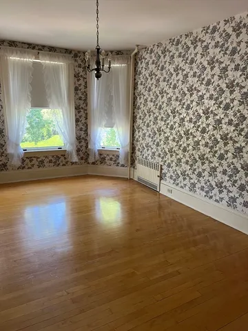 a view of a room with window wooden floor and front door