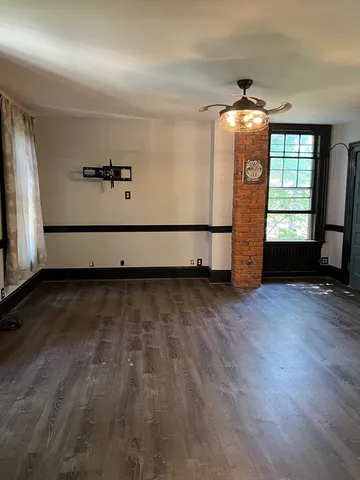 a view of room with window and wooden floor