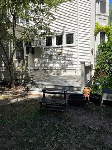a view of a house with backyard and sitting area