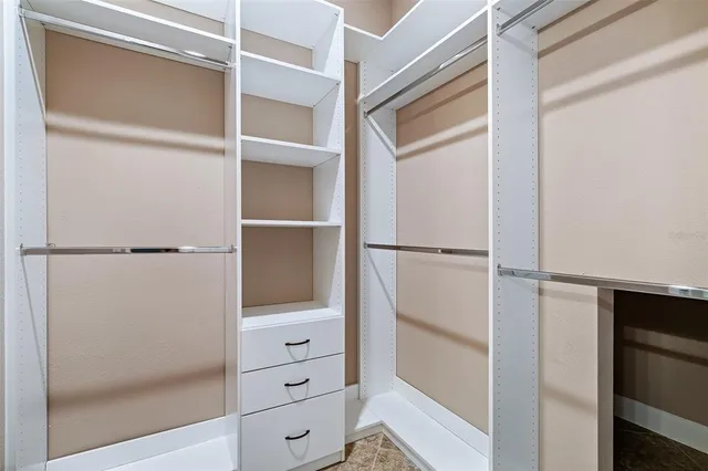 an empty room with ceiling fan and window