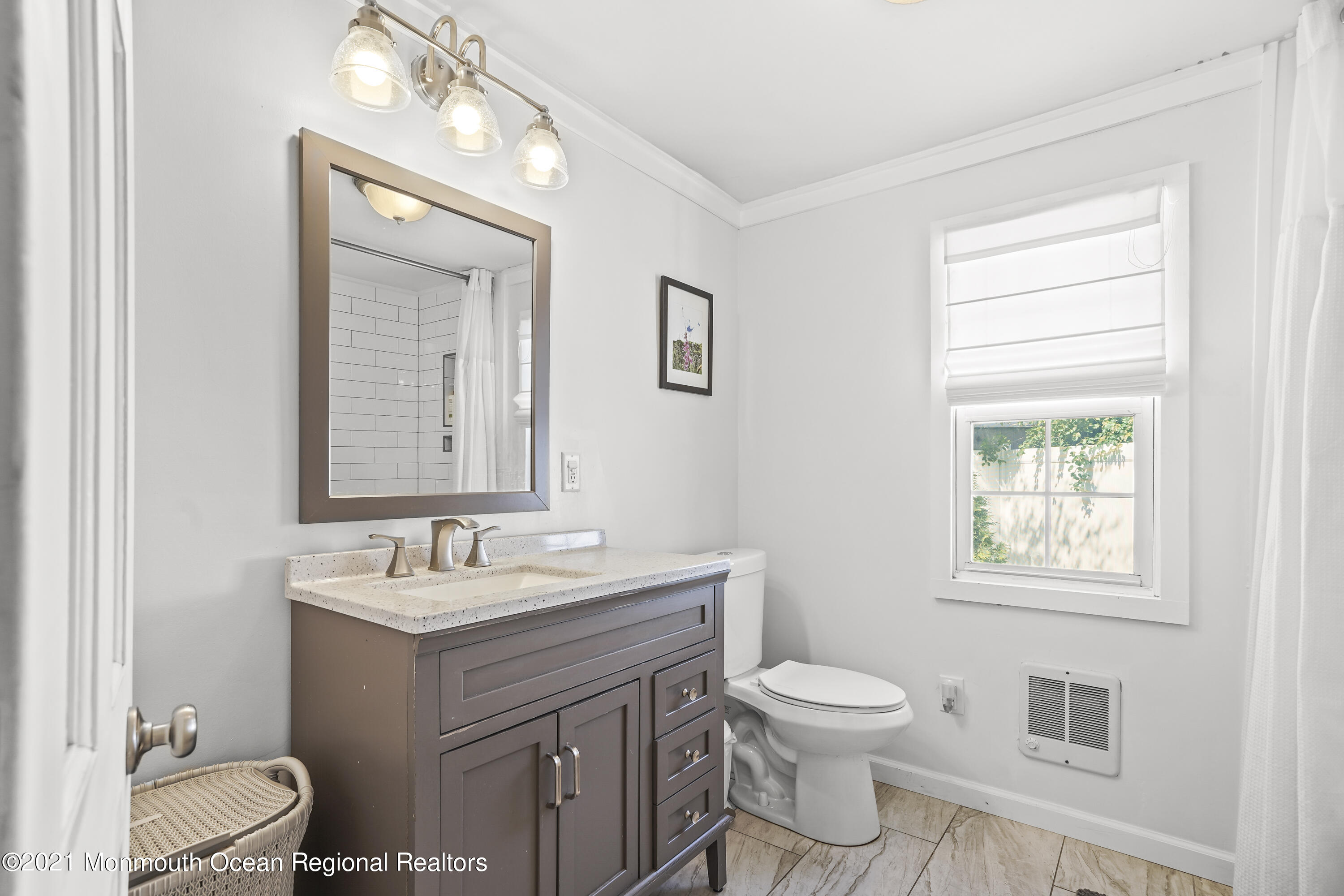 84 Breton Road Brick, NJ 08723 - Photo 13 of 19 a bathroom with a toilet a sink a mirror a window and vanity