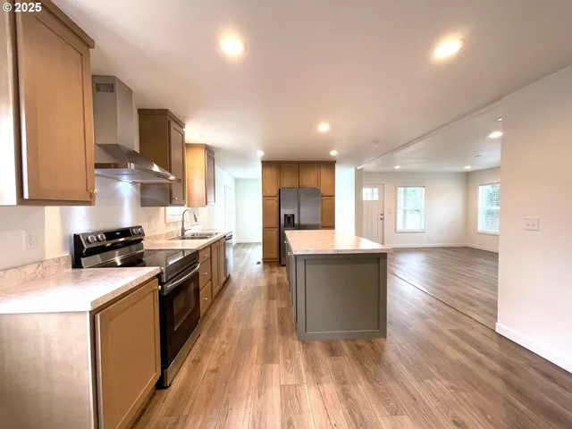 a kitchen with granite countertop a stove top oven a sink a counter space and cabinets