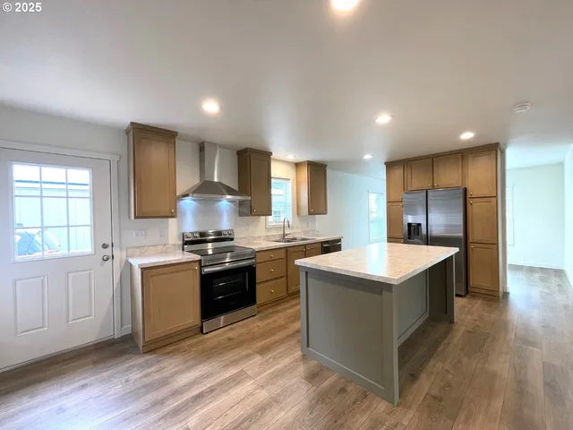 a kitchen with stainless steel appliances granite countertop a sink stove and refrigerator