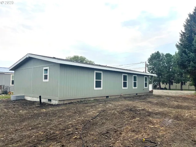 a backyard of a house with table and chairs