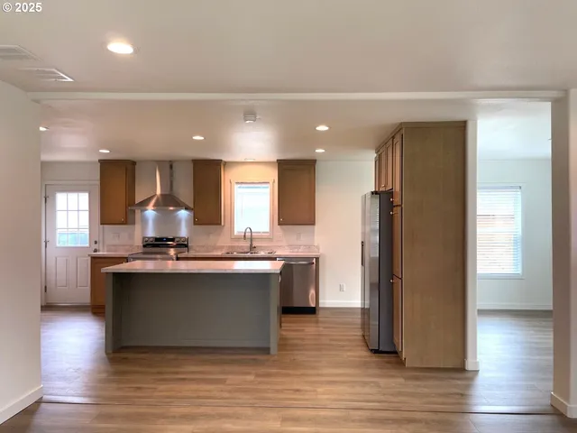 a view of kitchen with stainless steel appliances granite countertop a stove and a refrigerator