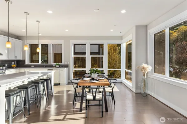 a dining room with wooden floor a chandelier a glass table and chairs