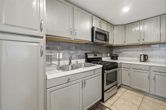 a kitchen with stainless steel appliances granite countertop a sink stove and microwave