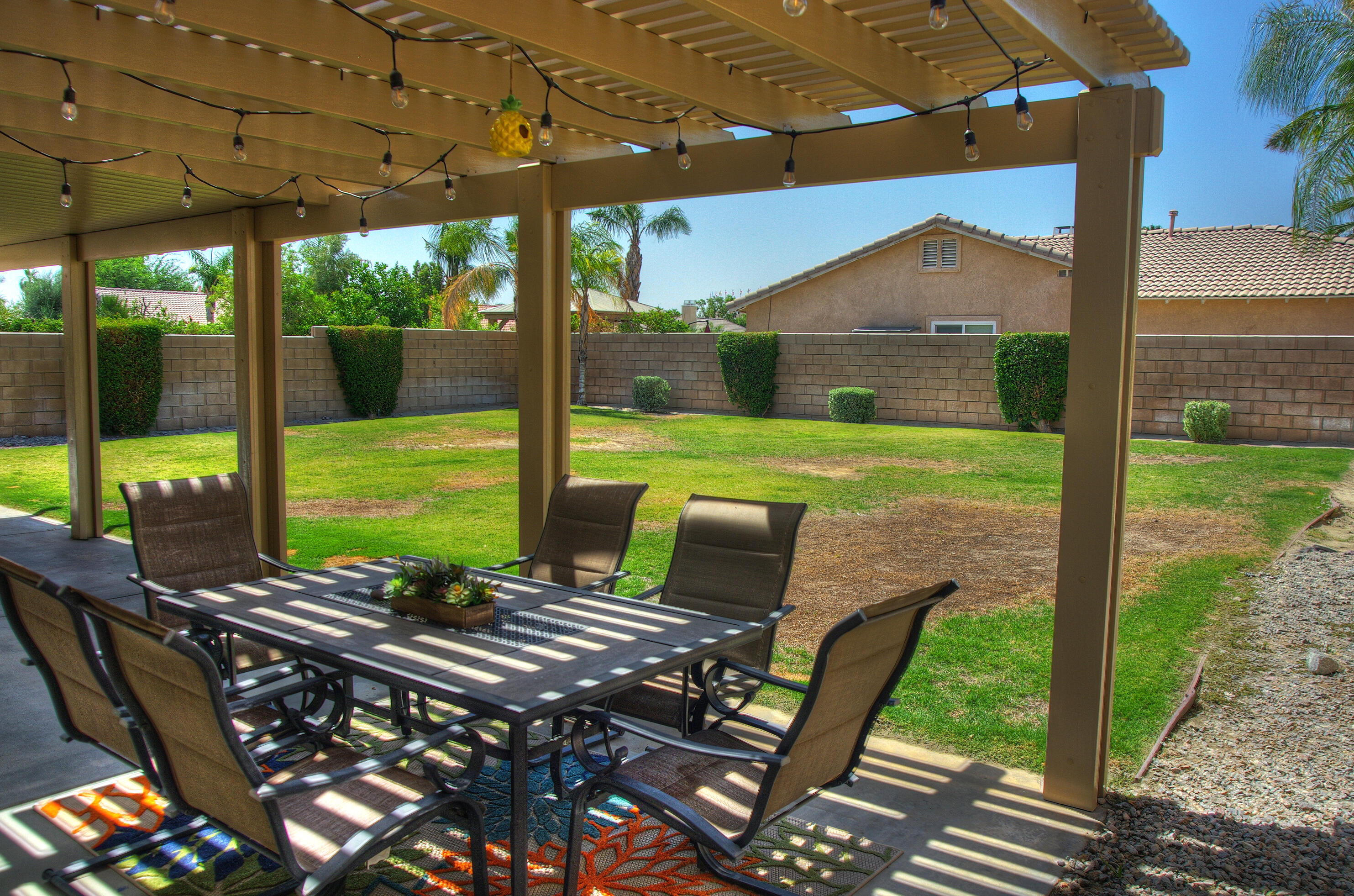 79379 Paseo Del Rey La Quinta, CA 92253 - Photo 20 of 24 a view of a patio with a table chairs and a backyard