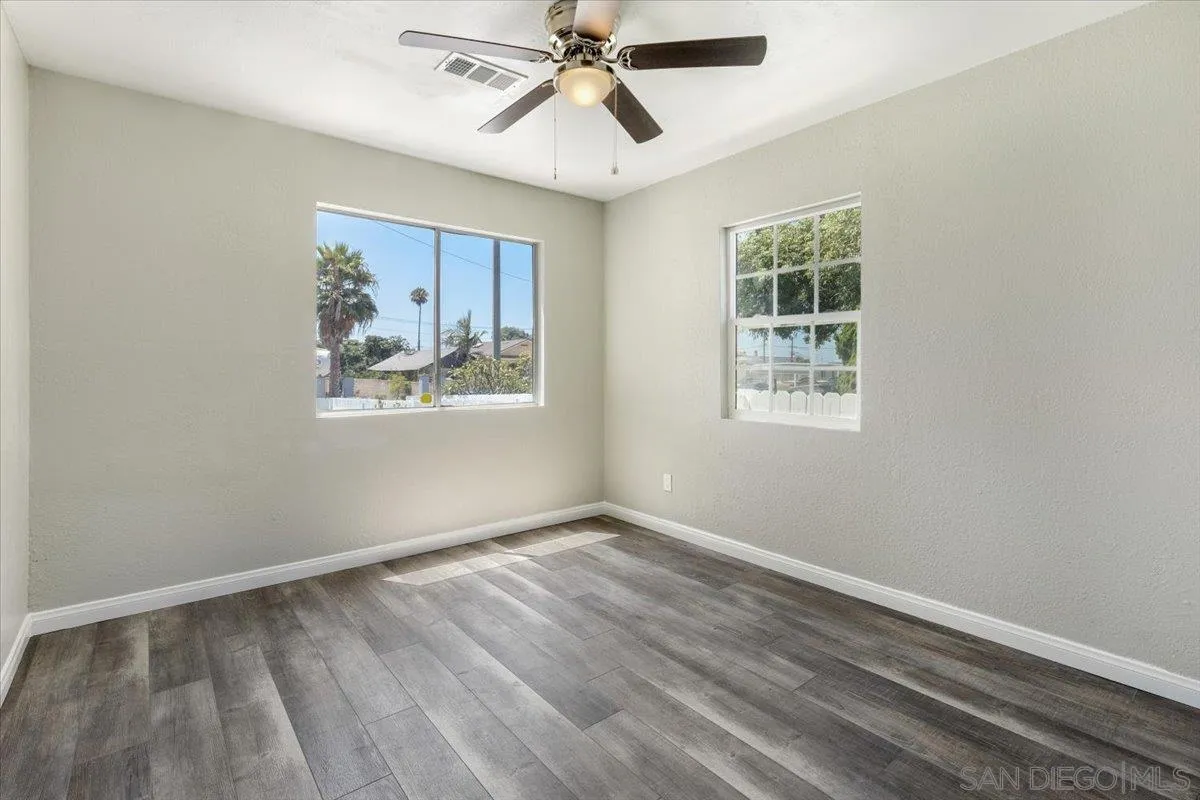 230 Zenith Street Chula Vista, CA 91911 - Photo 12 of 21 an empty room with wooden floor ceiling fan and windows