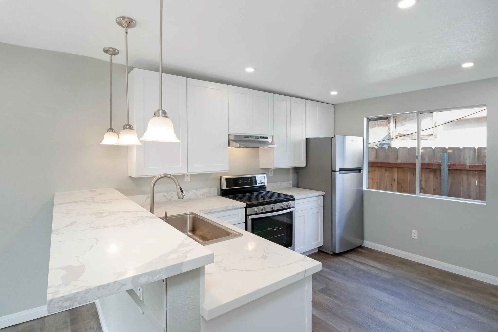 230 Zenith Street Chula Vista, CA 91911 - Photo 18 of 21 a kitchen with stainless steel appliances granite countertop a sink a stove a refrigerator and island with wooden floor