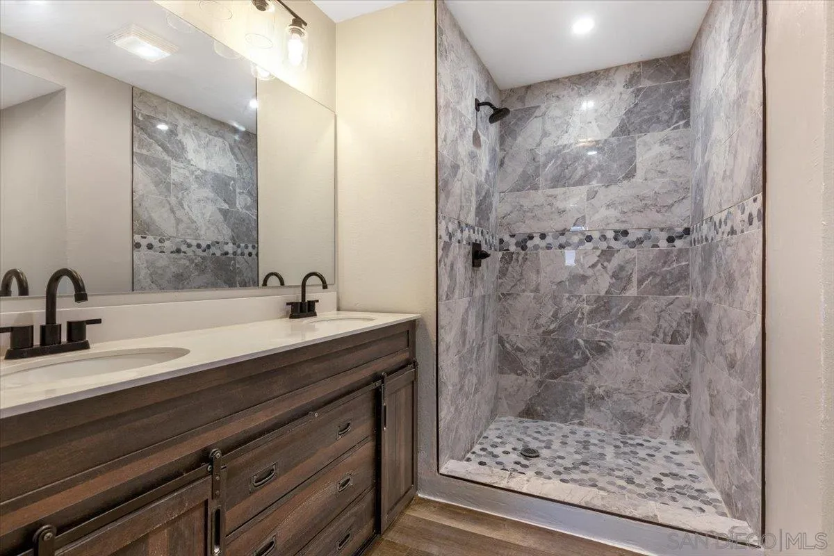 230 Zenith Street Chula Vista, CA 91911 - Photo 9 of 21 a bathroom with a granite countertop sink a mirror and shower