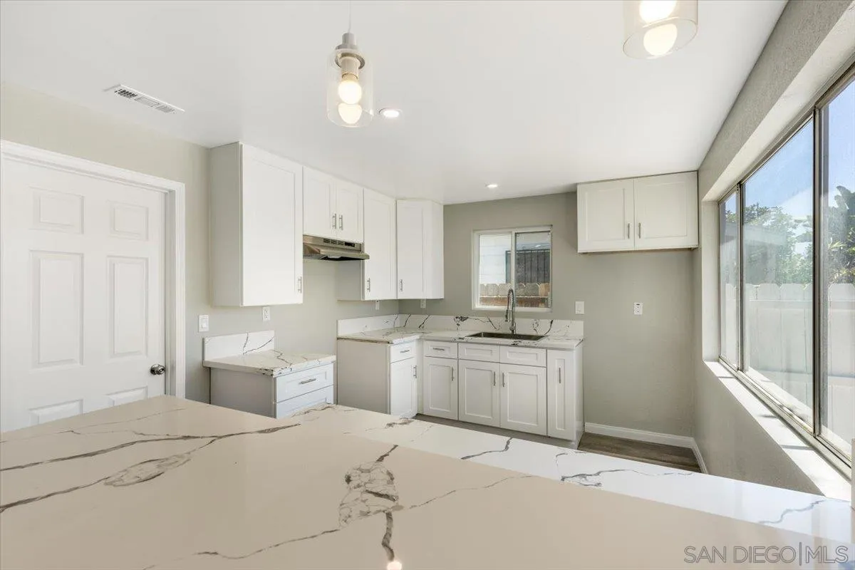 230 Zenith Street Chula Vista, CA 91911 - Photo 10 of 21 a kitchen with stainless steel appliances granite countertop a refrigerator a stove and white cabinets with wooden floor