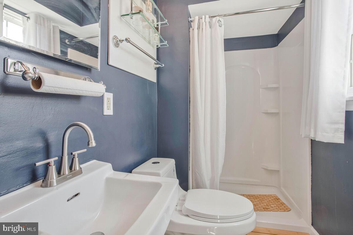 3709 29th Street Chesapeake Beach, MD 20732 - Photo 15 of 71 a bathroom with a sink a toilet and a mirror