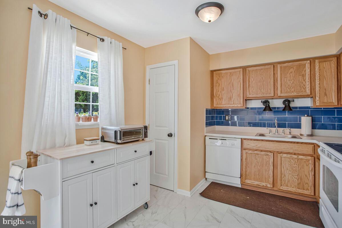 3709 29th Street Chesapeake Beach, MD 20732 - Photo 9 of 71 a kitchen with granite countertop white cabinets and white appliances
