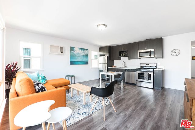 a kitchen with stainless steel appliances kitchen island hardwood floor and a sink