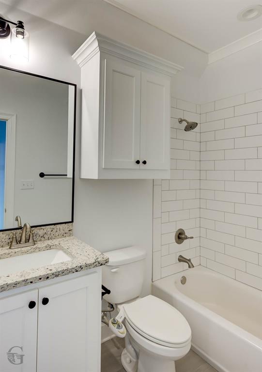 605 Meridian Way Benton, LA 71006 - Photo 14 of 29 Bathroom featuring a white subway tile shower surround, a white vanity with granite-look countertop, and a built-in wall cabinet with crown molding