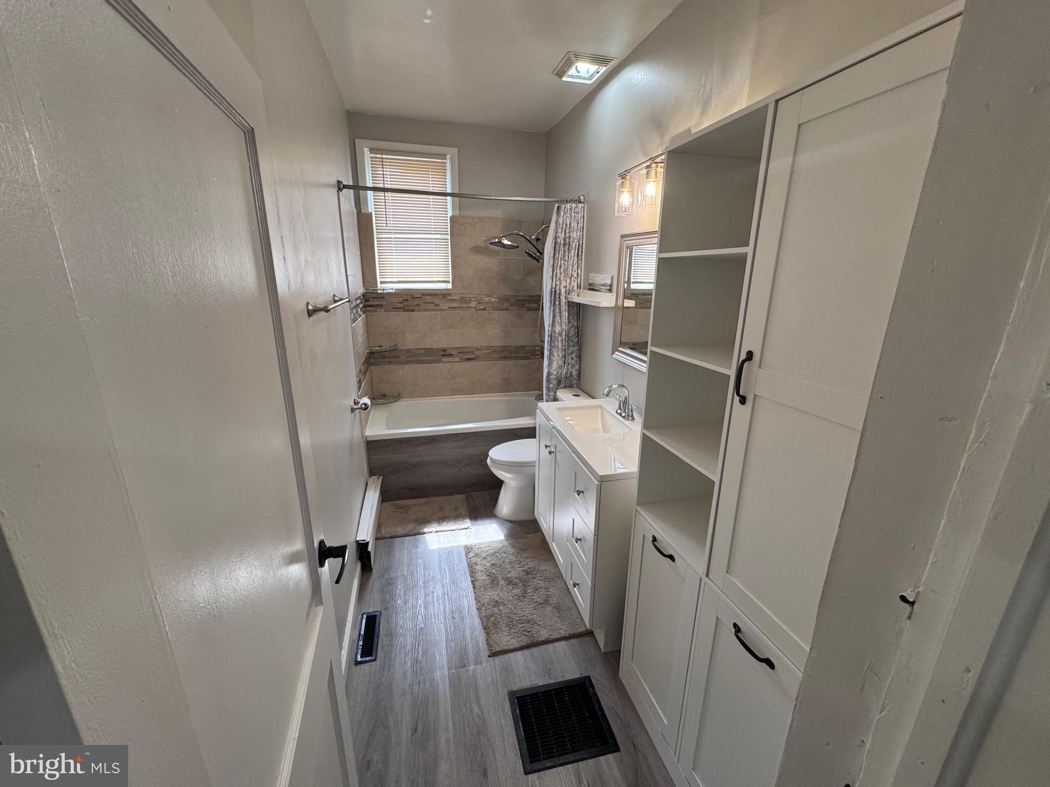 222 Townsend Avenue Baltimore, MD 21225 - Photo 9 of 24 a bathroom with a glass door shower a toilet and a sink