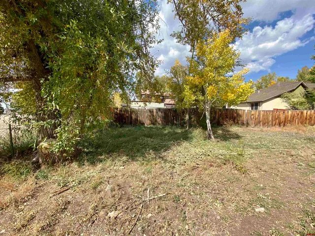 a view of a white house with a yard