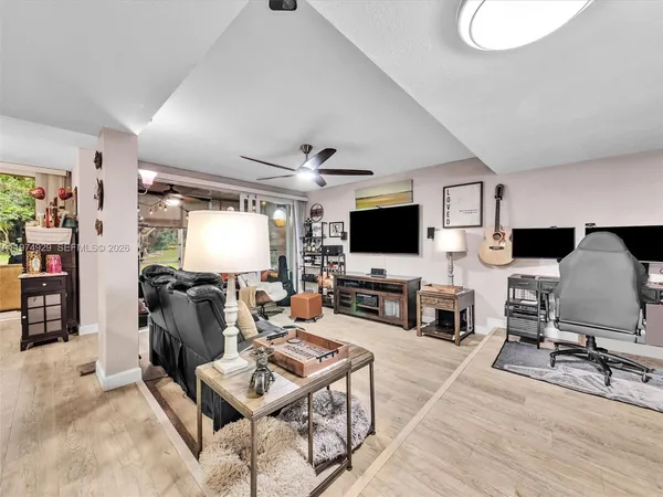 a living room with furniture kitchen view and a large window
