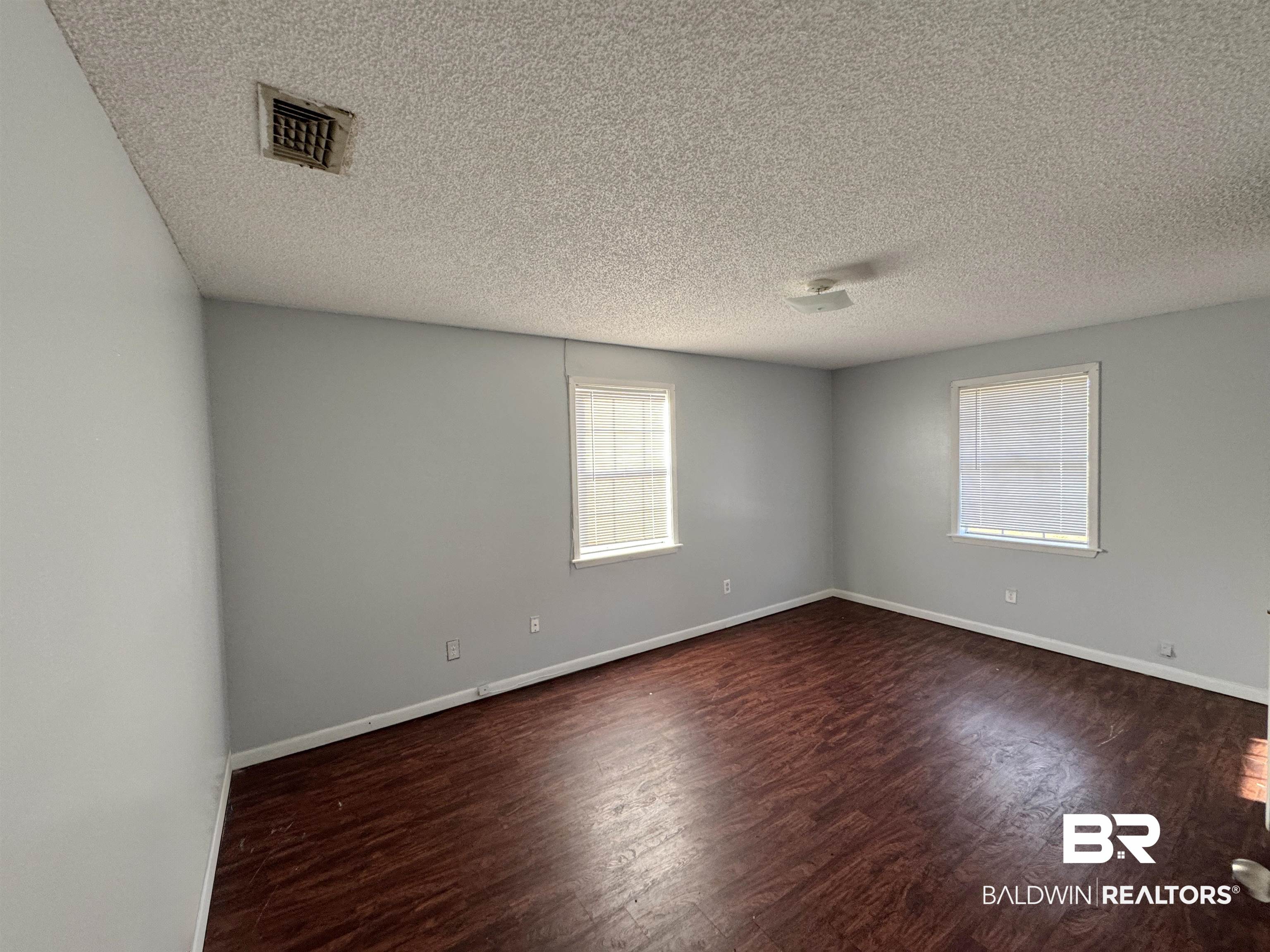 1227 Northgate Drive Atmore, AL 36502 - Photo 11 of 14 Unfurnished room with dark wood-style flooring and a textured ceiling